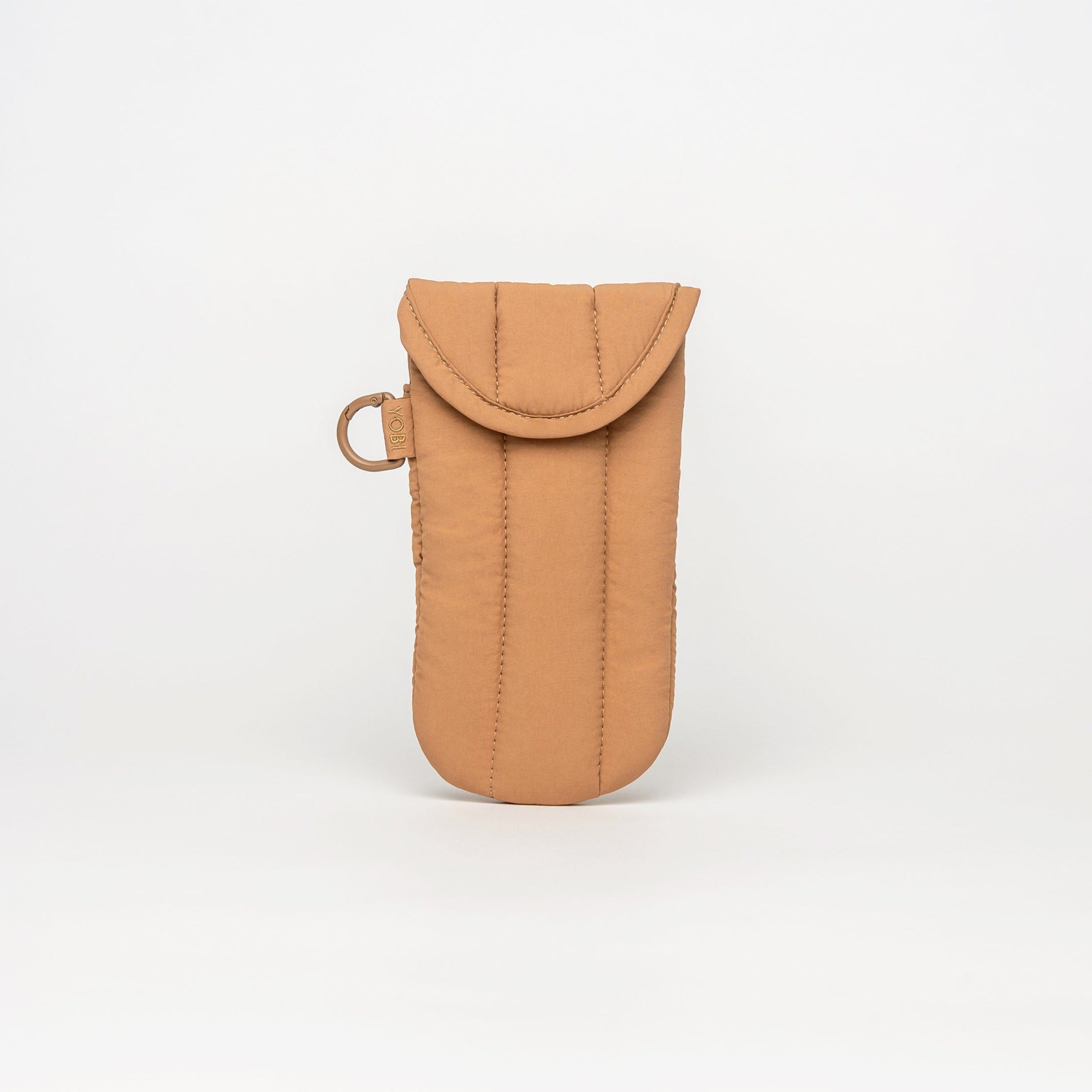 A tan quilted fabric pouch with a flap closure and a small metal ring, centered on a clean white studio background.