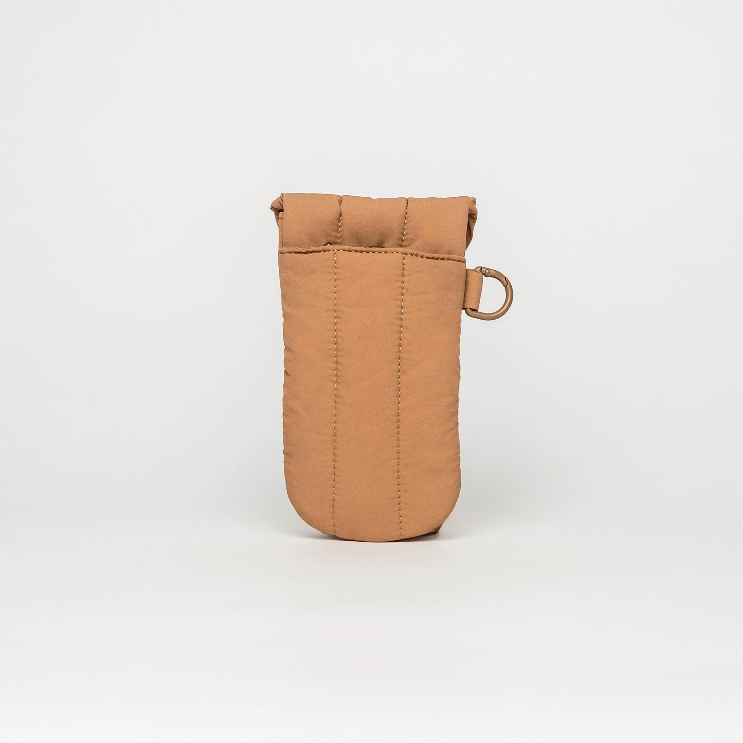 A tan quilted fabric pouch with a small metal ring attachment, standing upright on a white studio background.