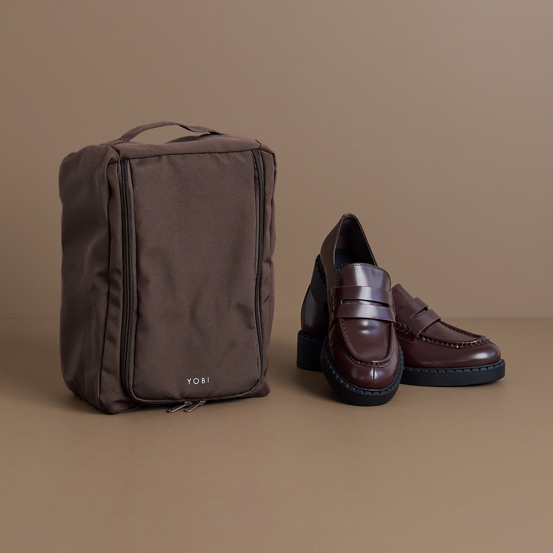 Brown shoe bag and loafers on a brown background